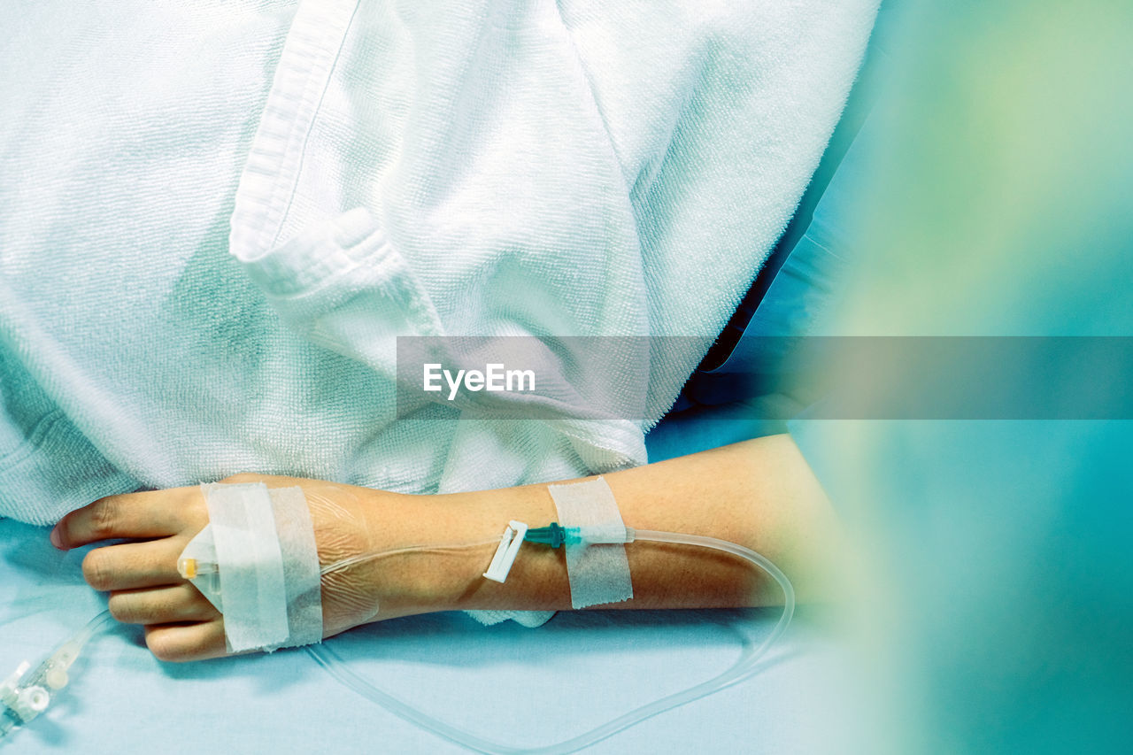 Close-up of woman hand with medical equipment on bed