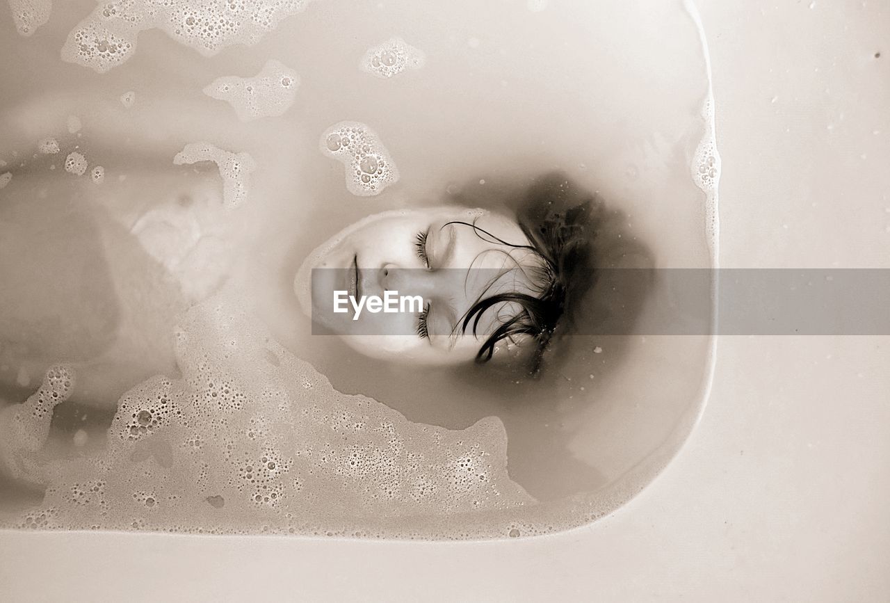 Close-up of boy resting in bathtub