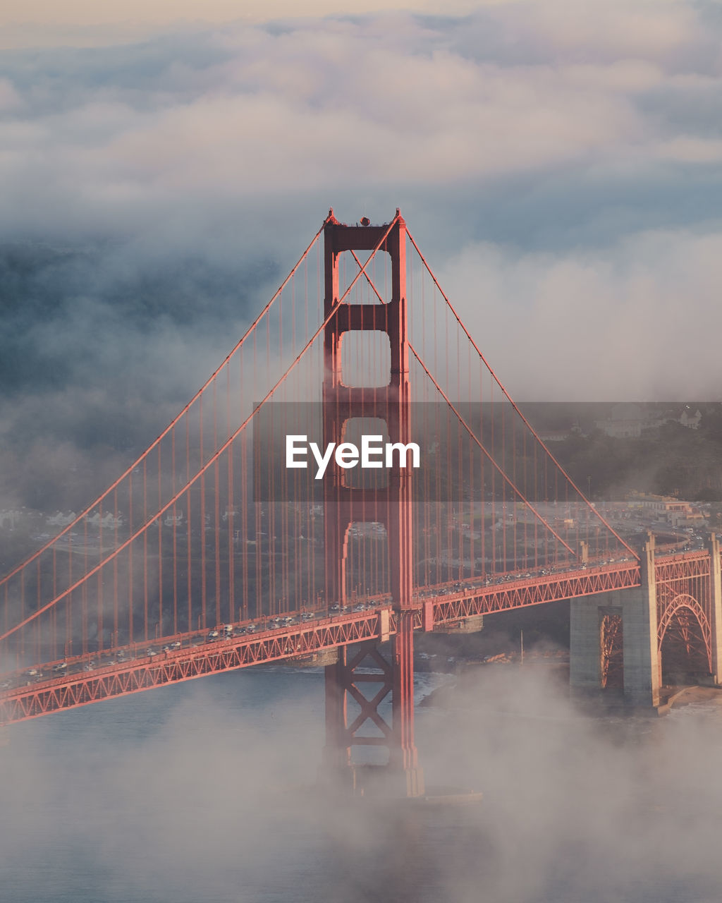 High angle view of golden gate bridge in city against cloudy sky