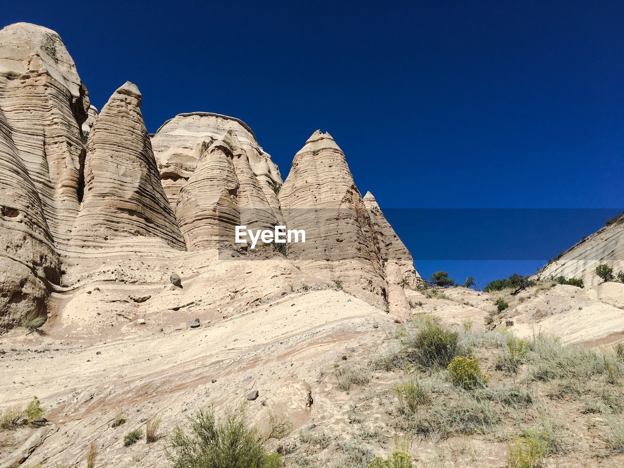 Low angle view of rock formations at kasha-katuwe tent rocks national monument against clear blue sky