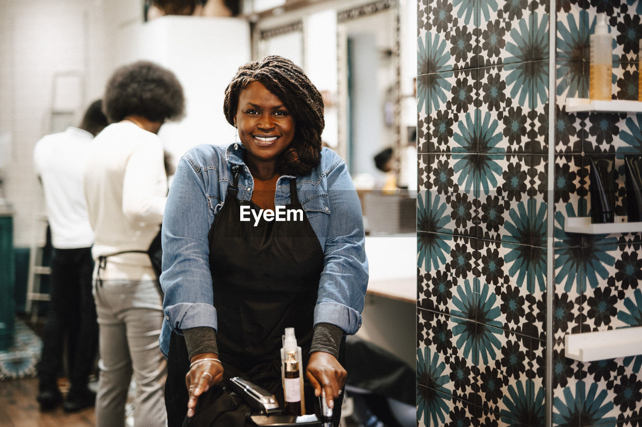 Portrait of smiling female barber at hair salon
