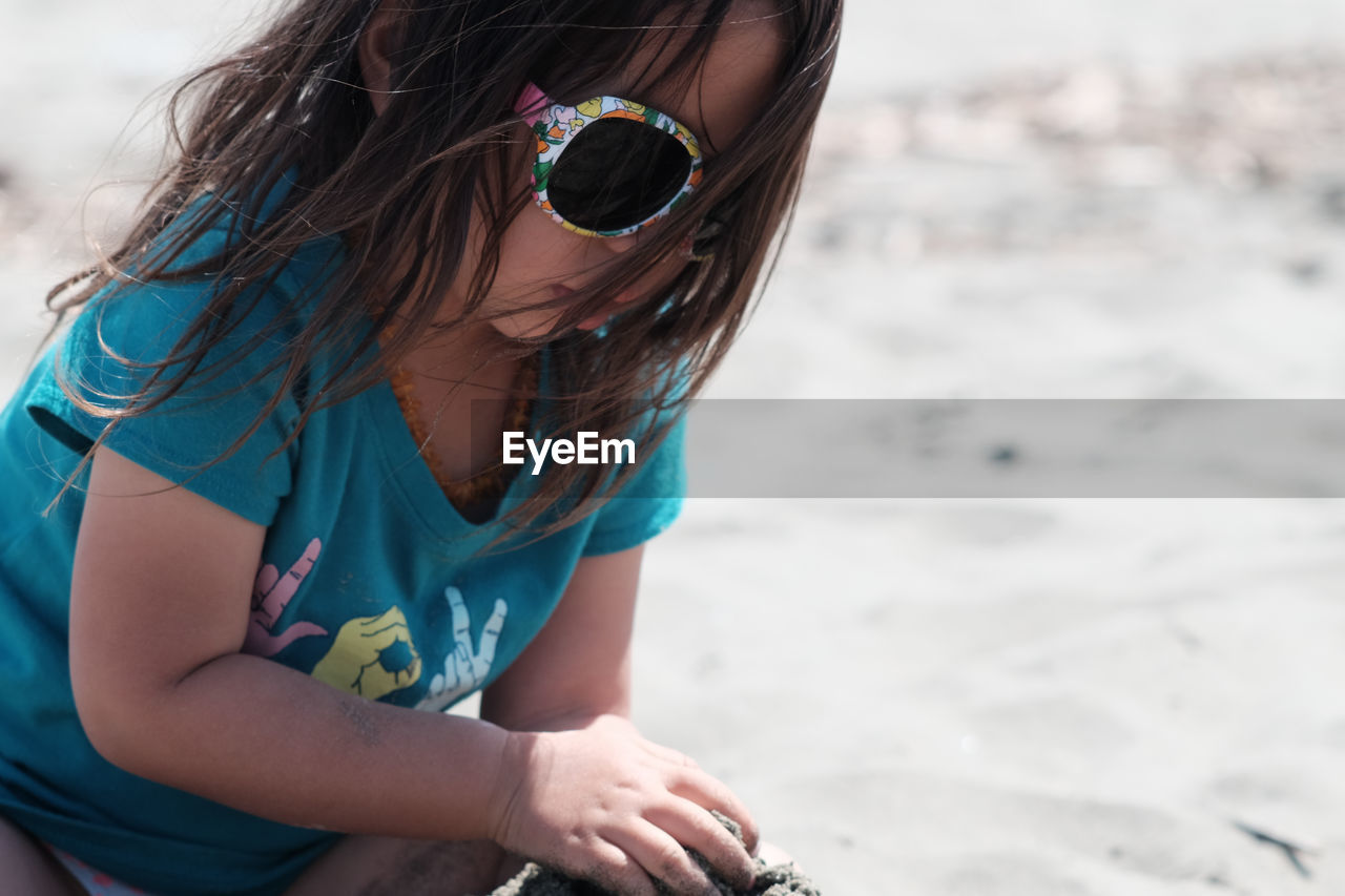 Girl playing with sand at beach