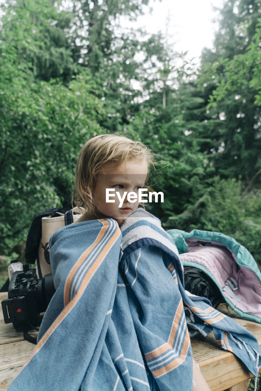 A portrait of a young girl in a towel after swimming in oregon.