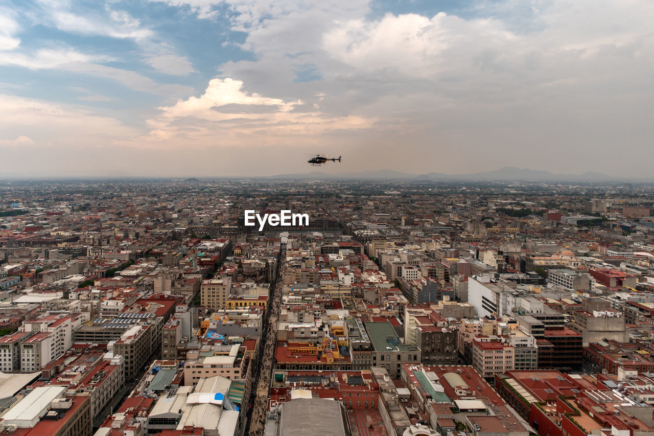 Aerial view of buildings in city against sky