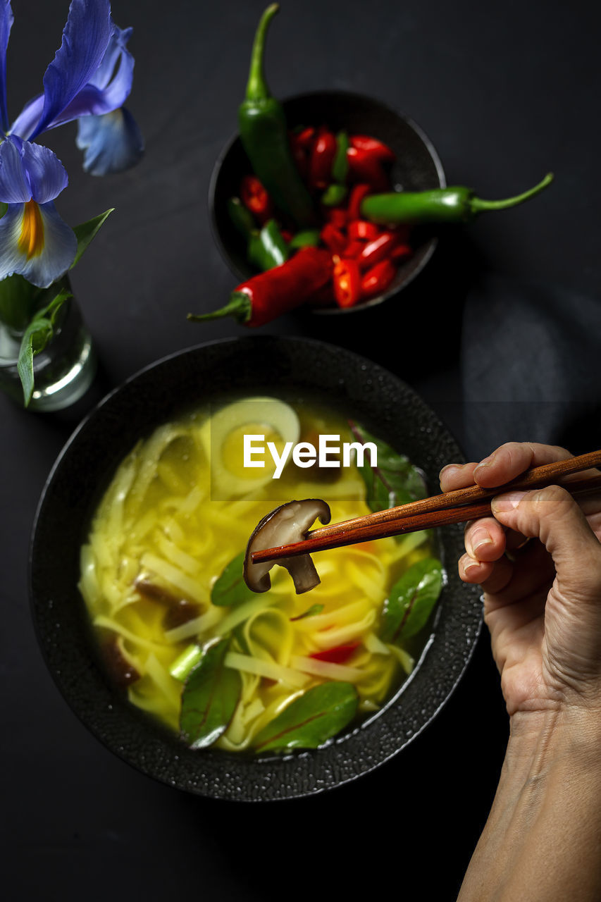 Cropped hand of person eating food at table