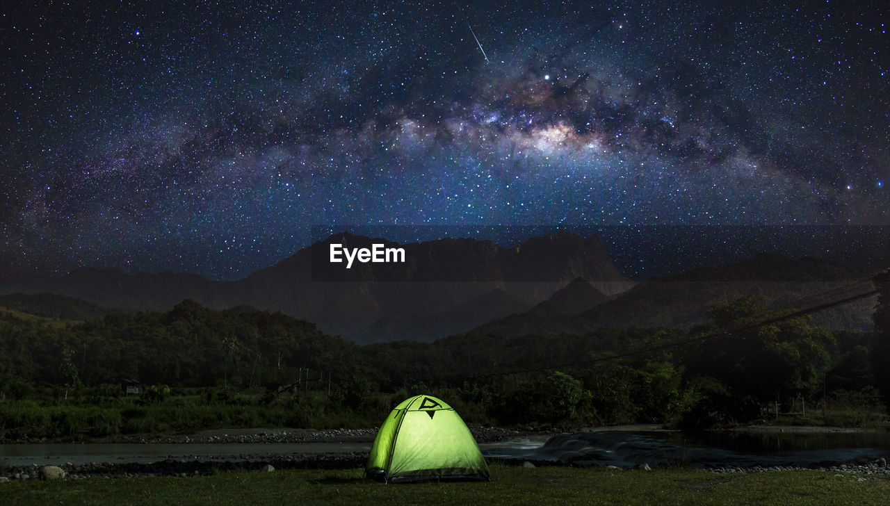 SCENIC VIEW OF MOUNTAIN AGAINST STAR FIELD