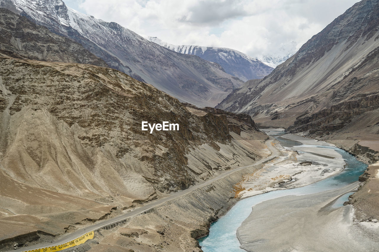 Aerial view of a river meeting another river with different color at a sangam in indus valley.