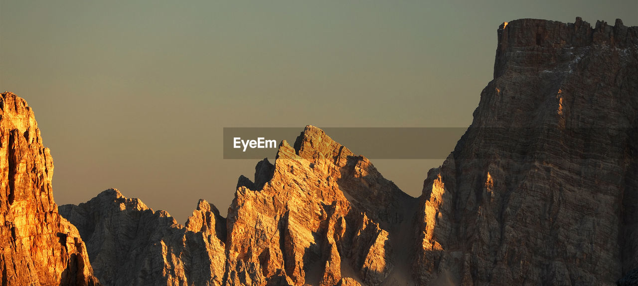 Panoramic view of rocky mountains against clear sky