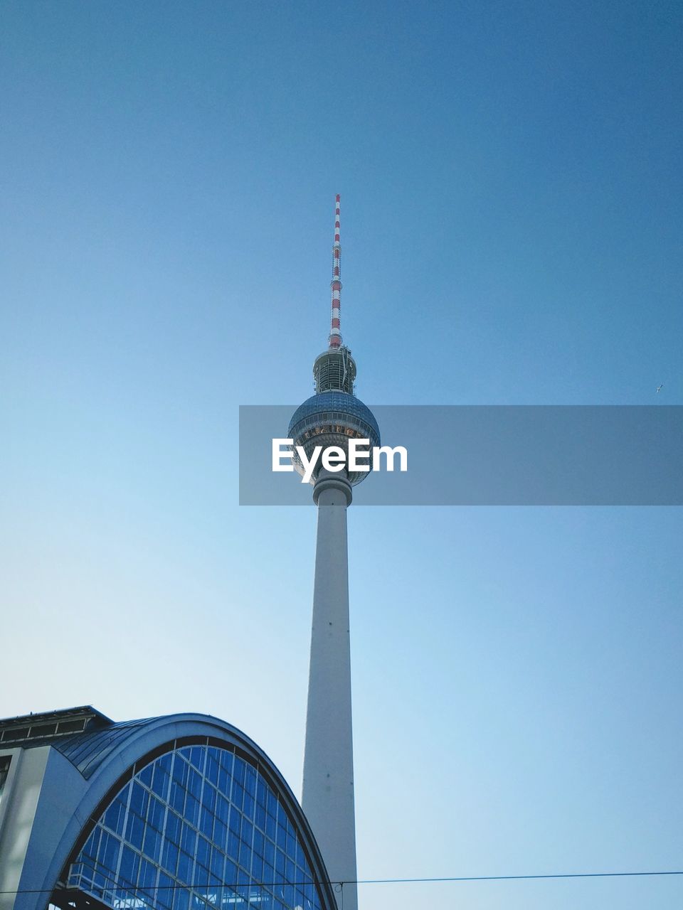 Low angle view of communications tower against blue sky