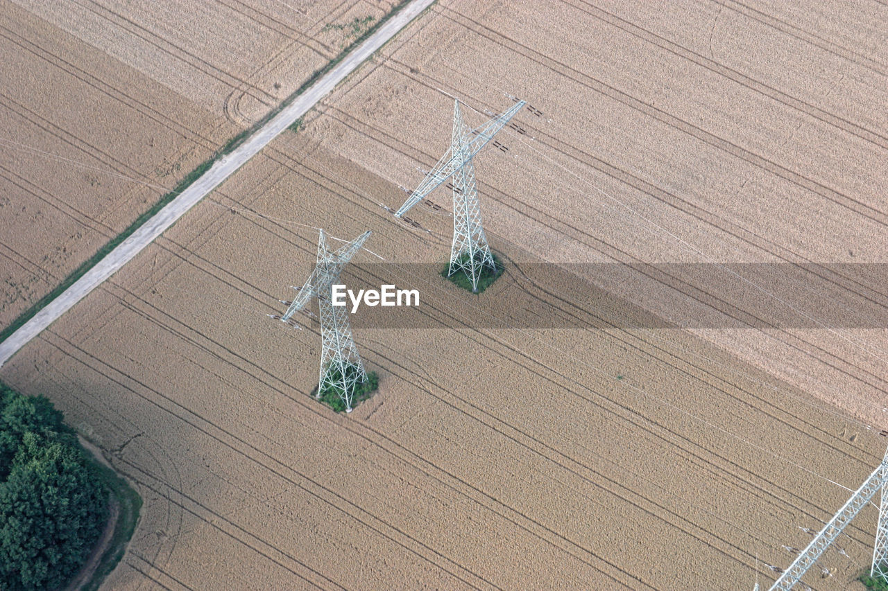 High angle view of electricity pylons on agricultural field