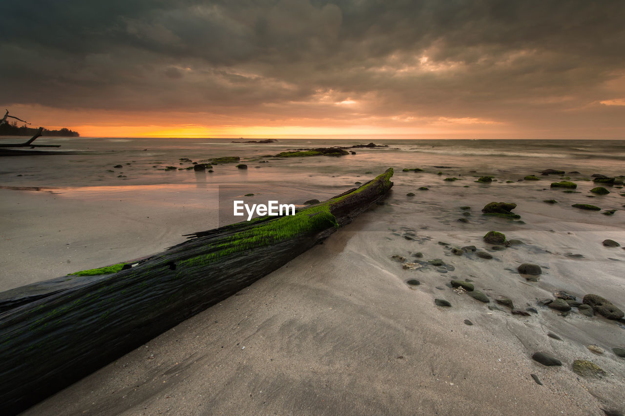 PANORAMIC VIEW OF BEACH AGAINST SKY DURING SUNSET