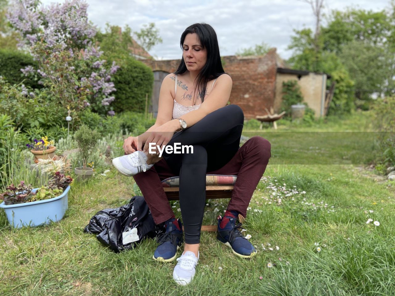 PORTRAIT OF YOUNG WOMAN SITTING ON LAND