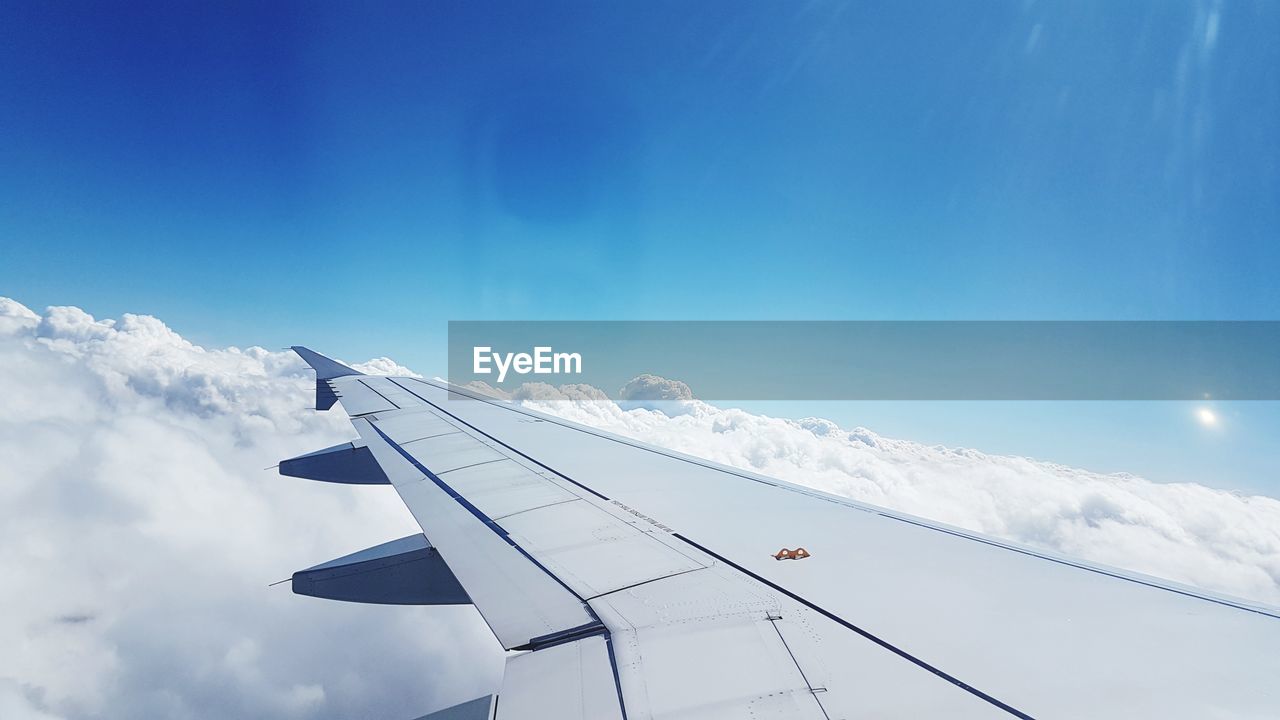 LOW ANGLE VIEW OF AIRPLANE FLYING OVER BLUE SKY