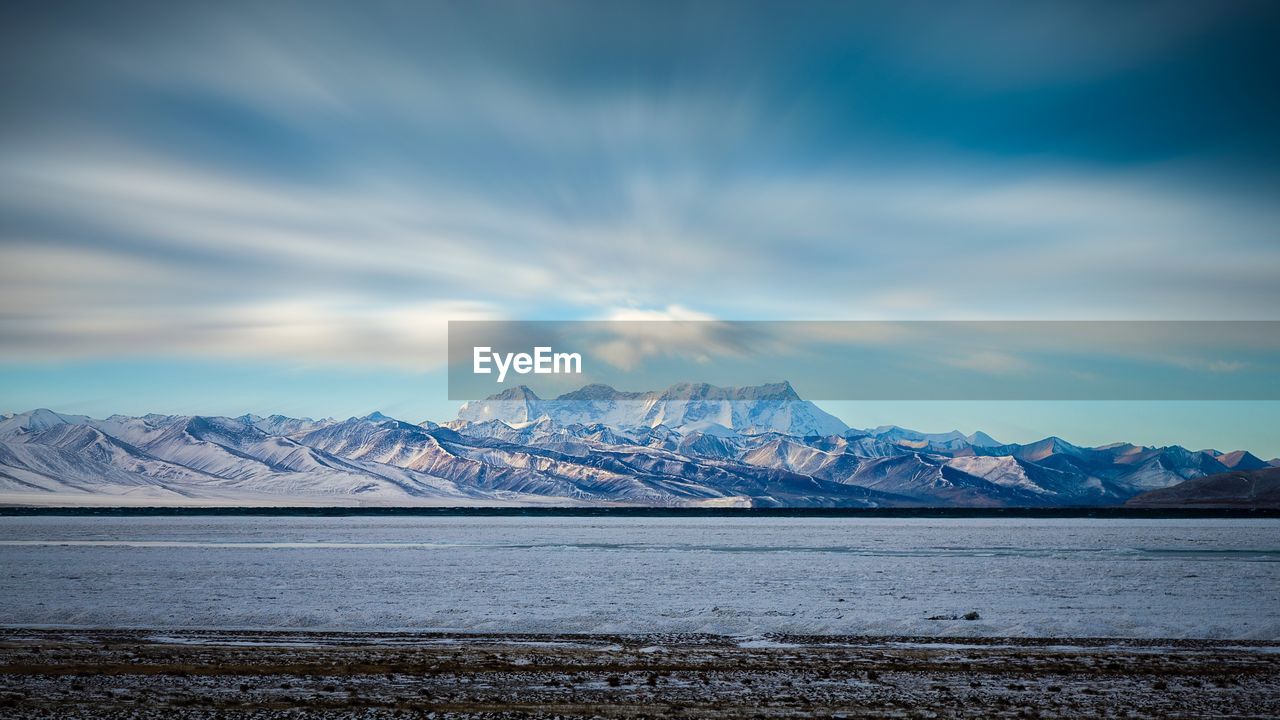 Scenic view of lake by mountains against sky