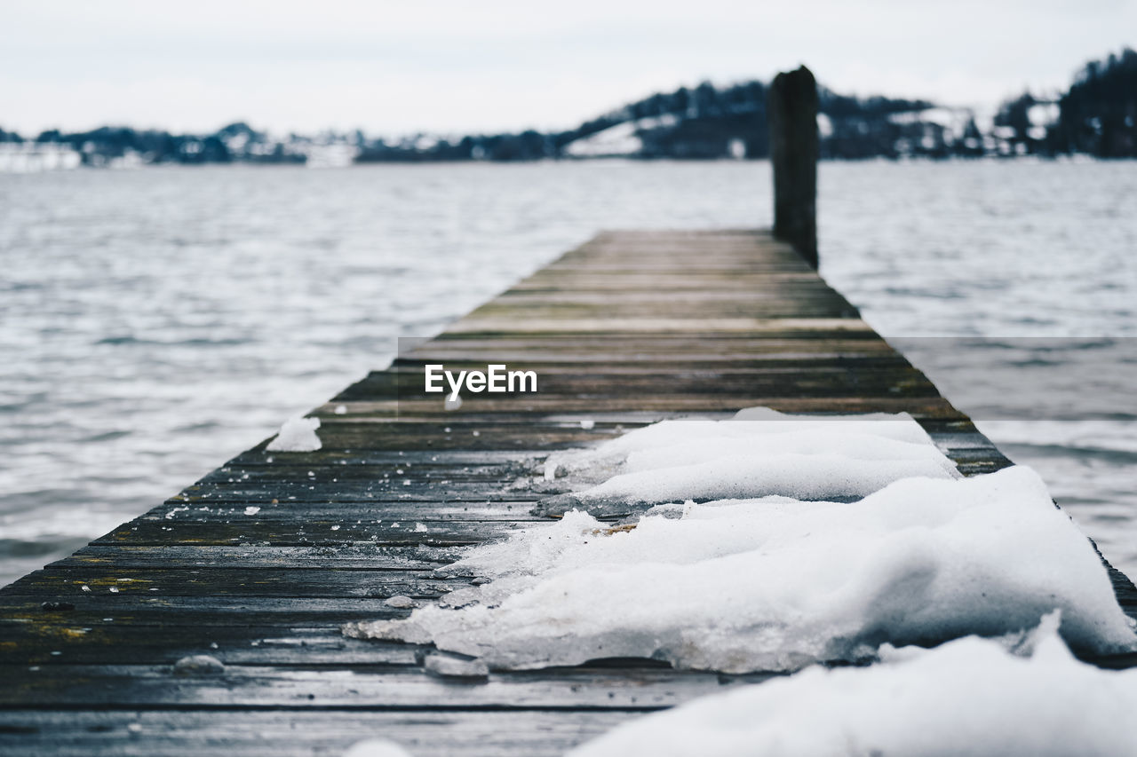 CLOSE-UP OF FROZEN PIER AGAINST SEA