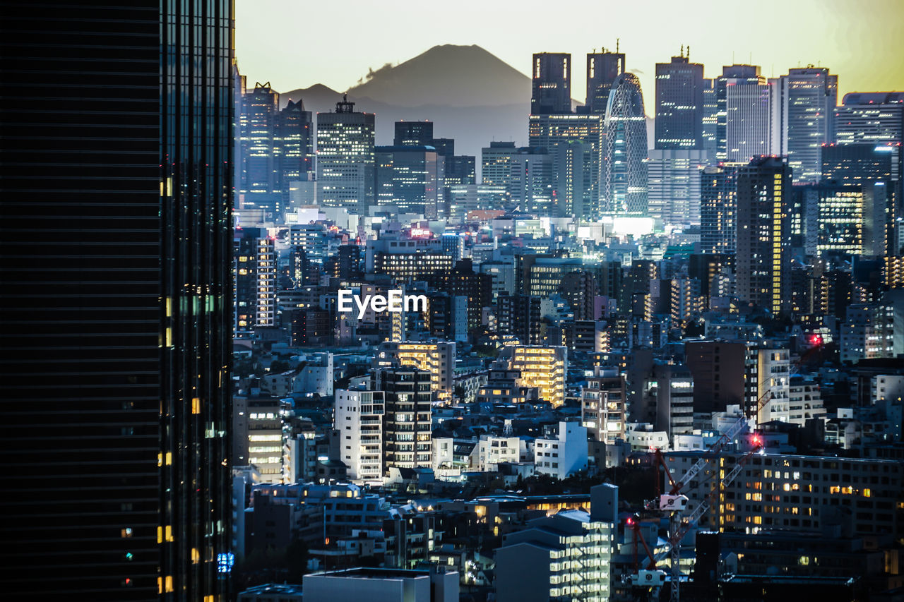 AERIAL VIEW OF ILLUMINATED CITY BUILDINGS AT NIGHT