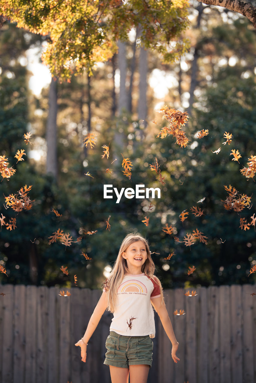 PORTRAIT OF WOMAN STANDING BY TREE