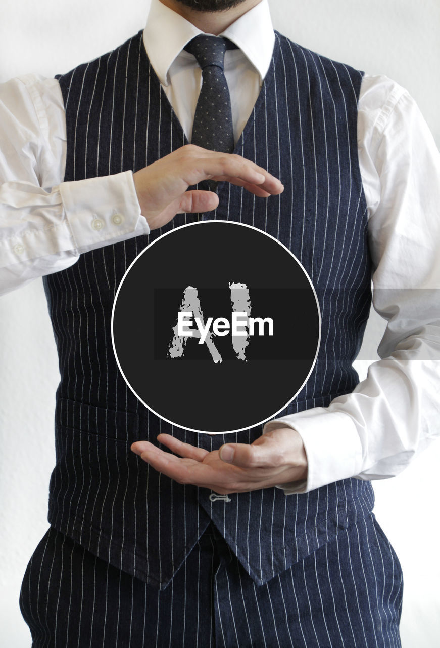 business, adult, one person, men, businessman, clothing, formal wear, holding, midsection, indoors, occupation, studio shot, corporate business, business finance and industry, hand, shirt, finance, sleeve, person, menswear, front view, necktie, professional occupation, tie