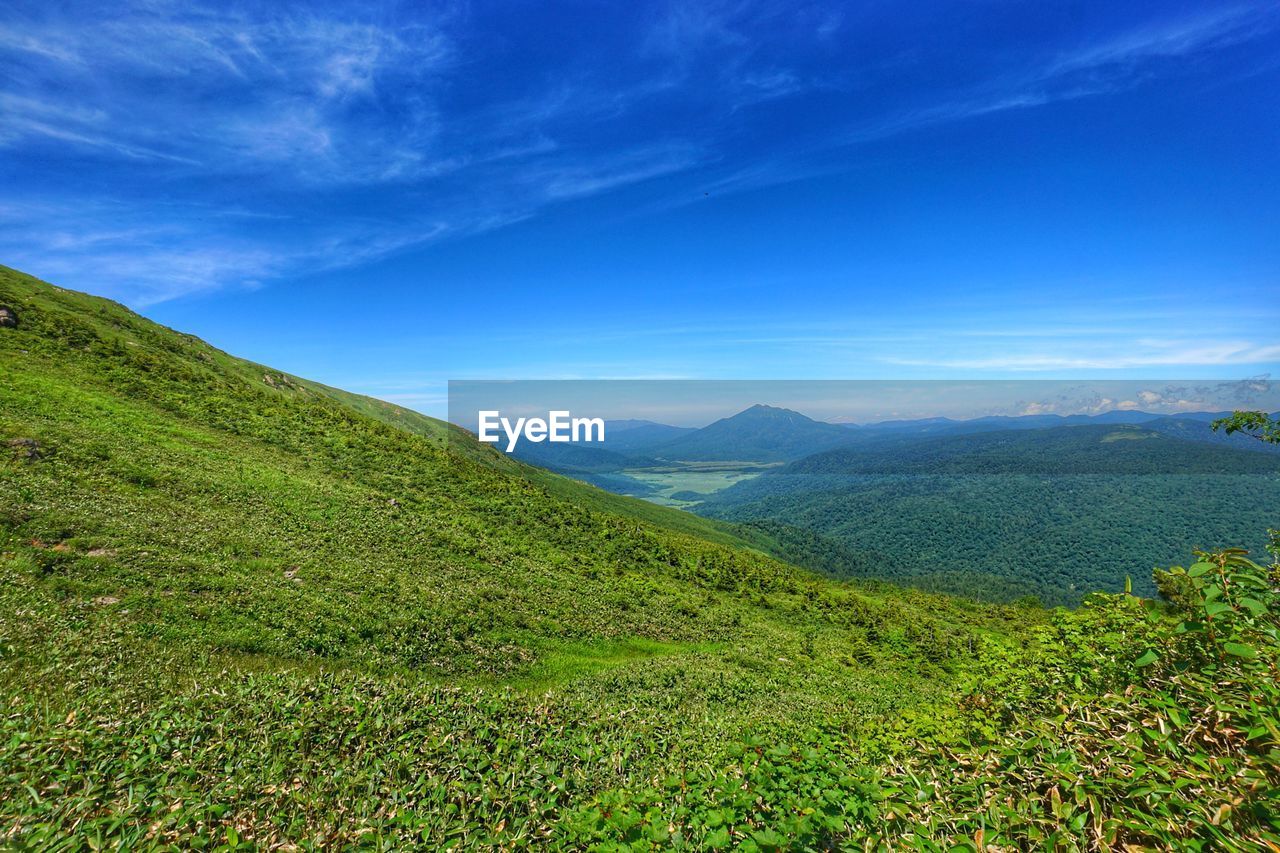 Scenic view of mountains against blue sky