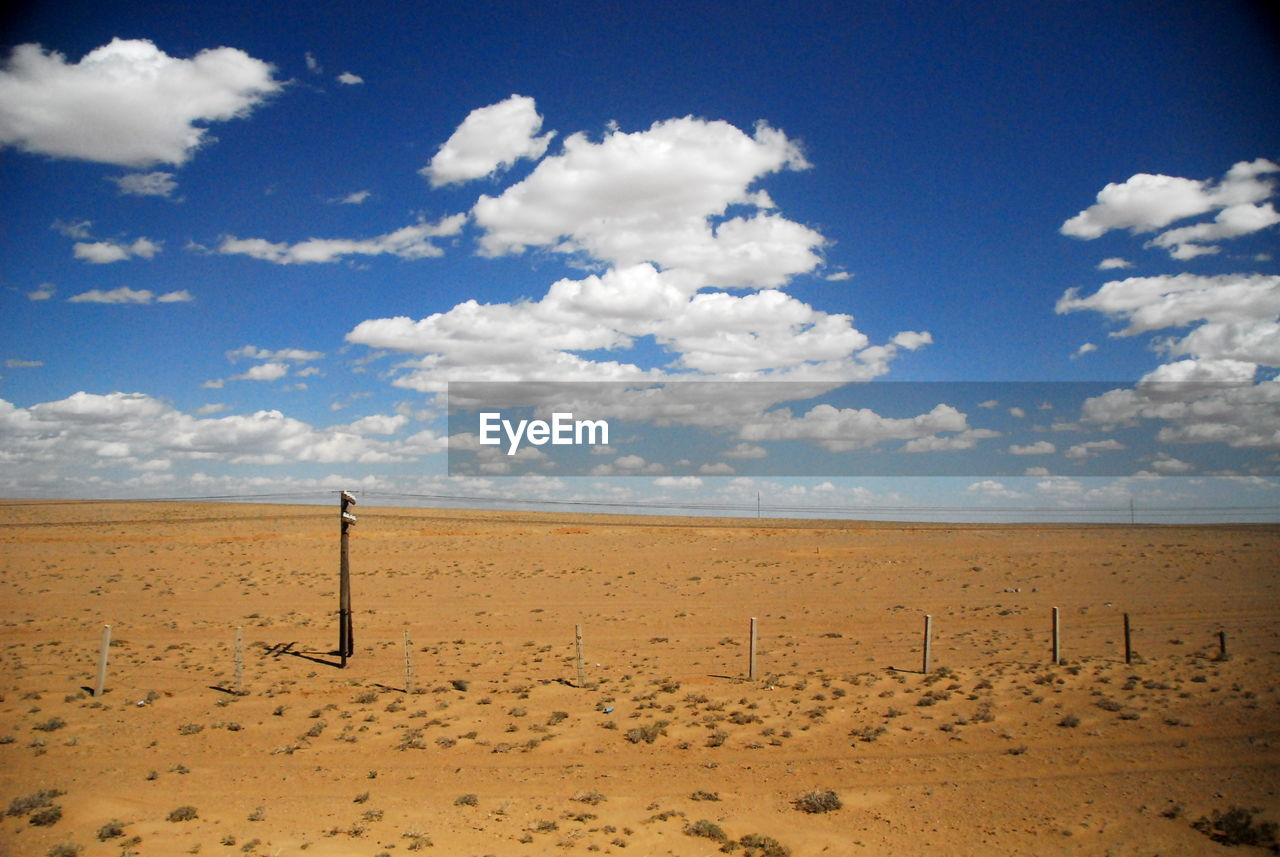 Scenic view of beach against cloudy sky