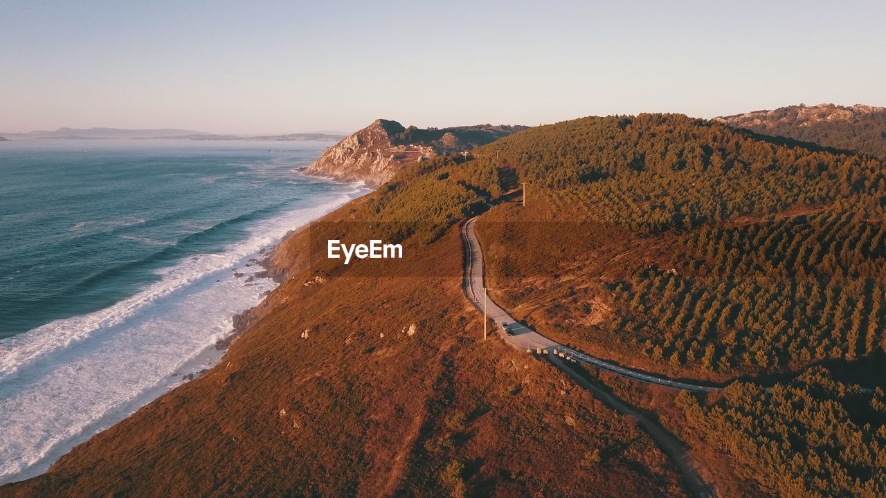 Scenic view of sea and landscape against clear sky