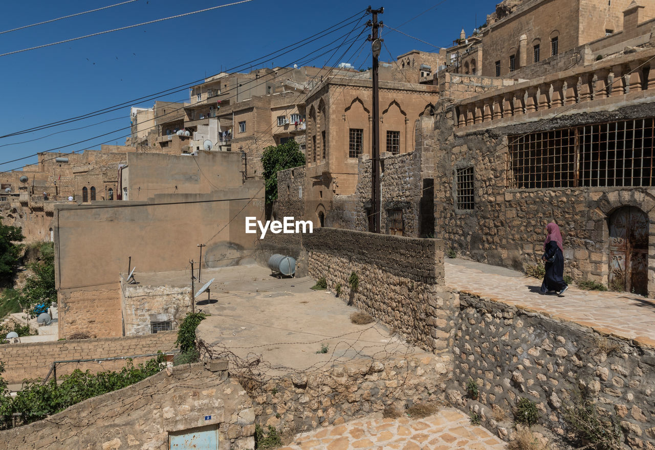 PEOPLE WALKING ON OLD BUILDING IN CITY