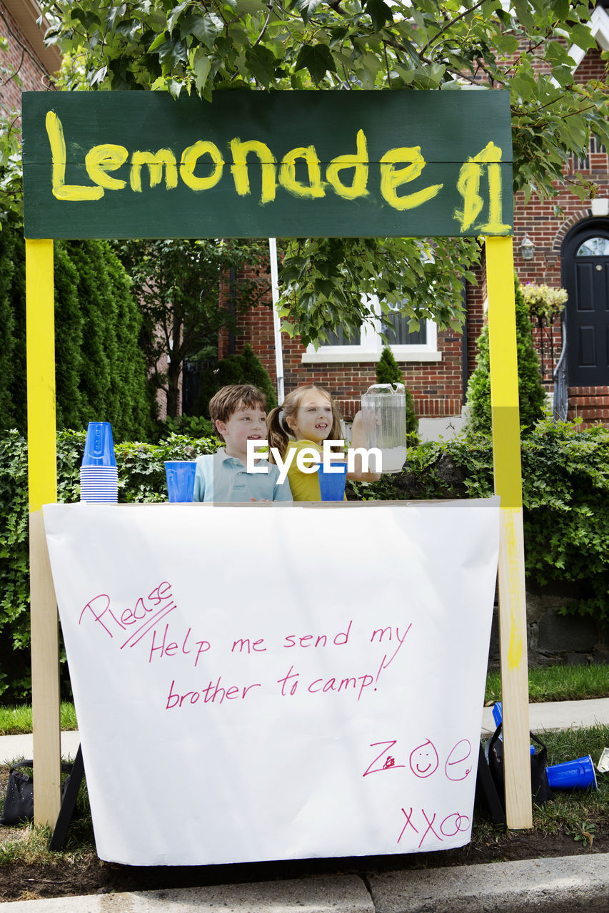 Kids at lemonade stand against house