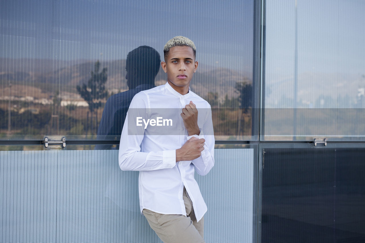 Portrait of young man standing in office