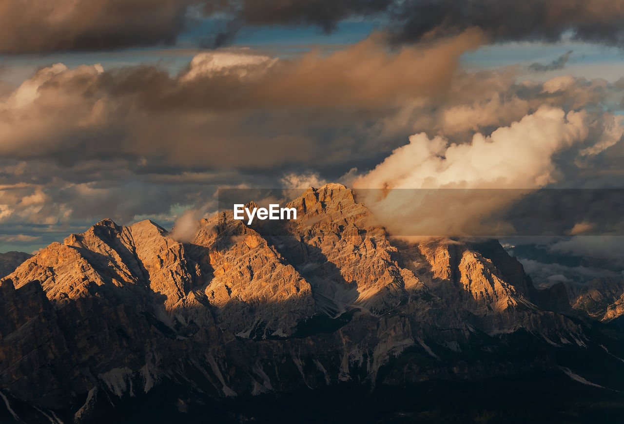 Scenic view of rocky mountains against cloudy sky