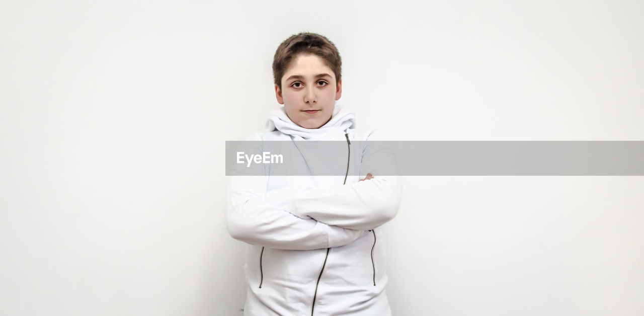 Portrait of boy standing on white background