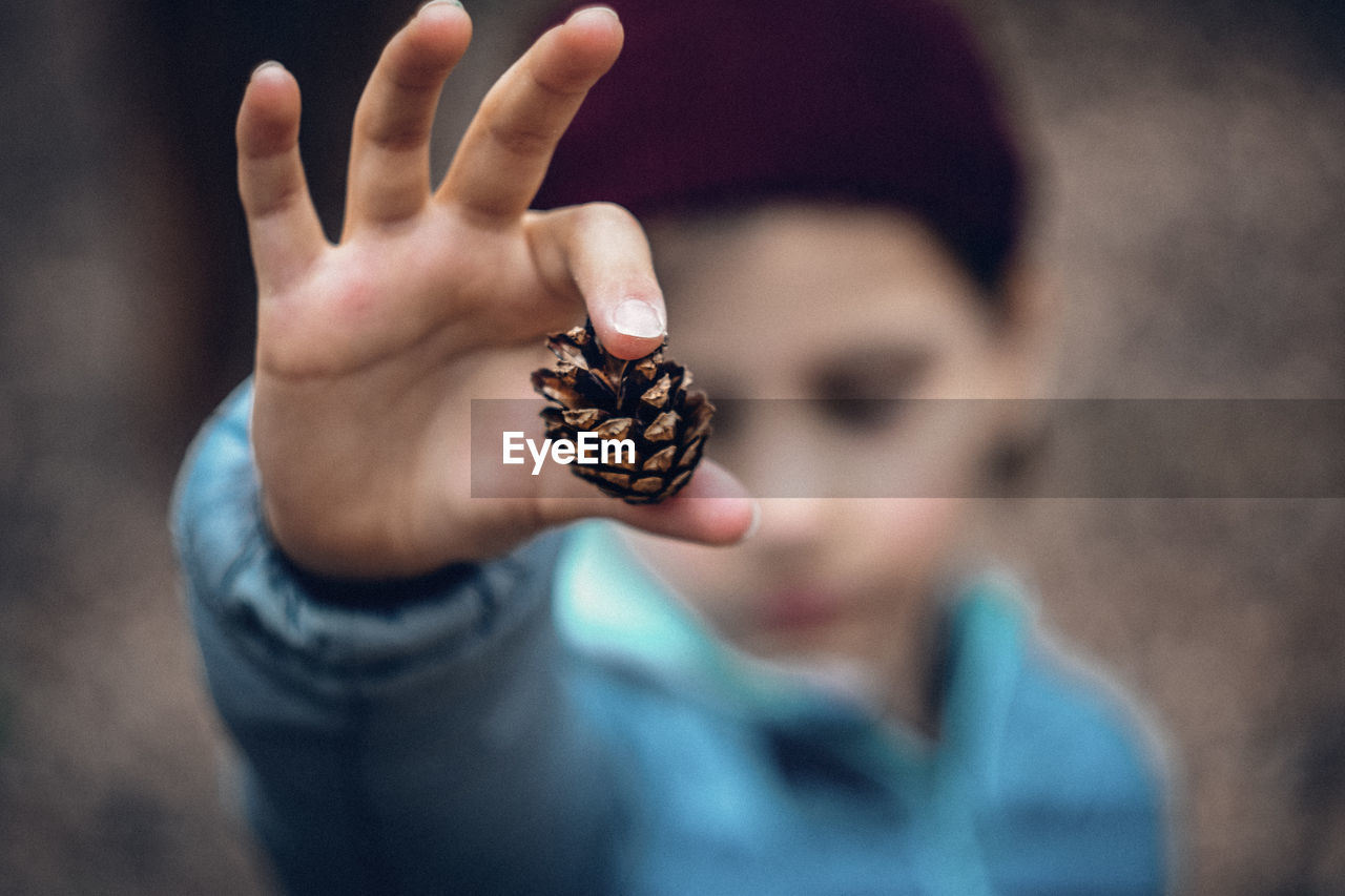 CLOSE-UP OF HUMAN HAND HOLDING GIRL WEARING MASK