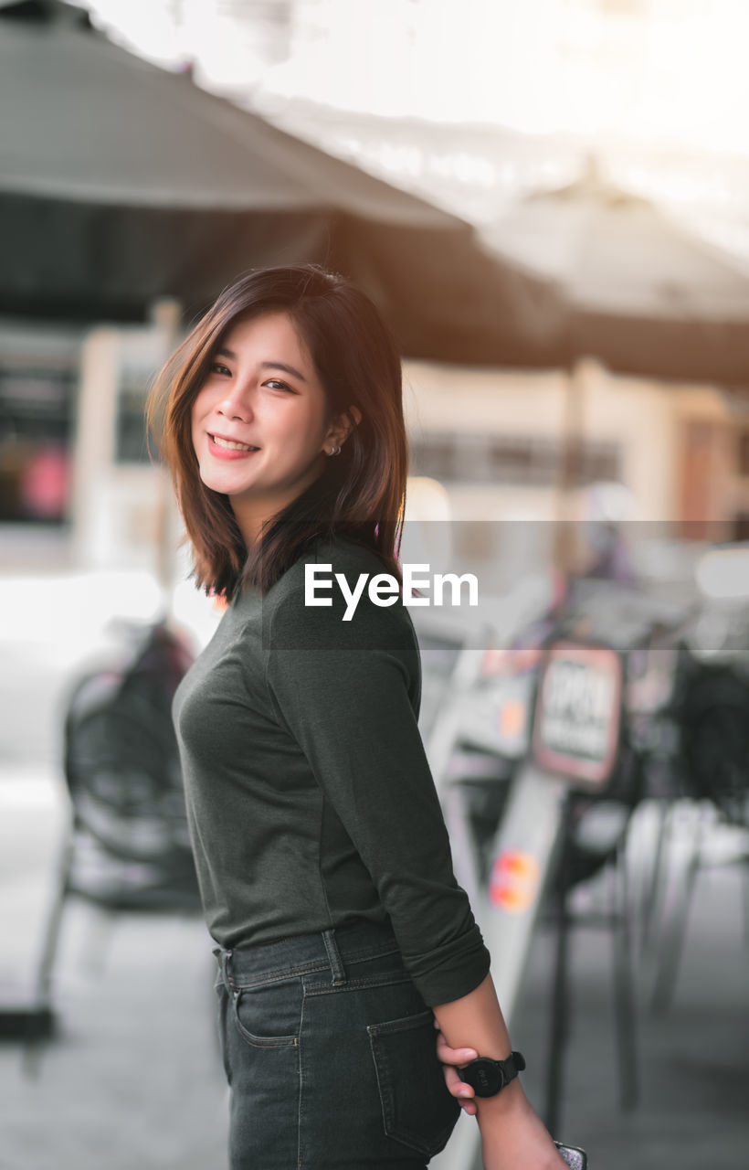 Portrait of smiling beautiful woman standing outdoors