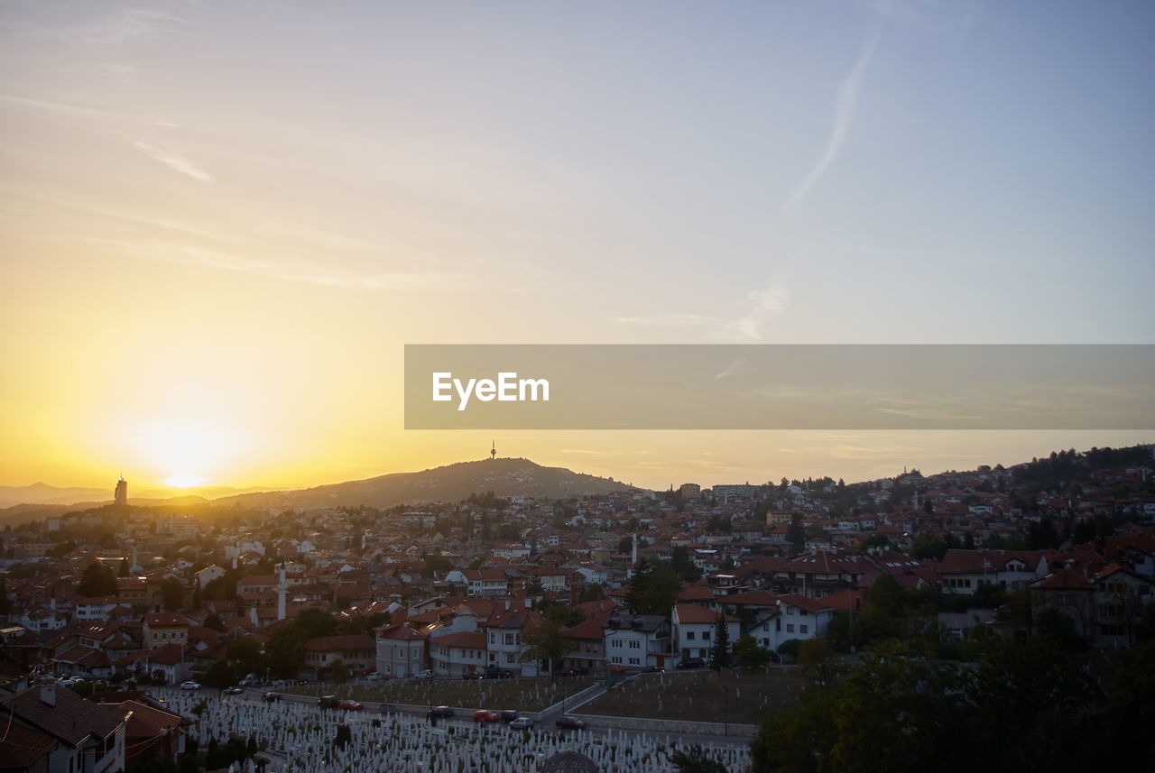 HIGH ANGLE SHOT OF TOWNSCAPE AGAINST SKY DURING SUNSET