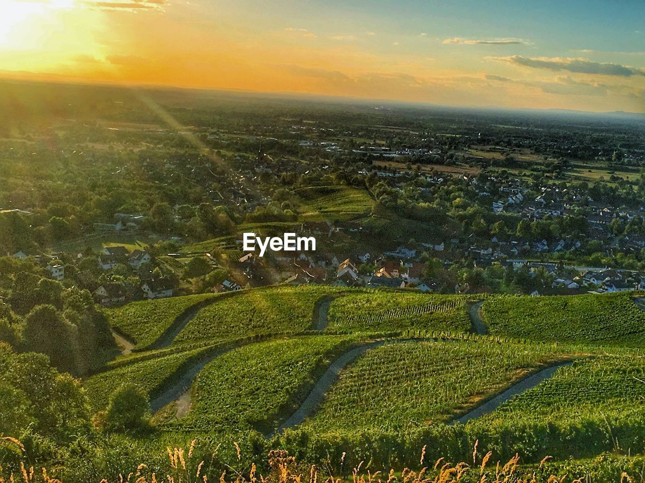 Aerial view of agricultural field against sky at sunset