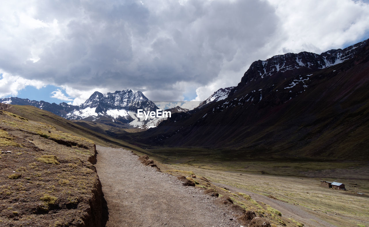 Road amidst snowcapped mountains against sky