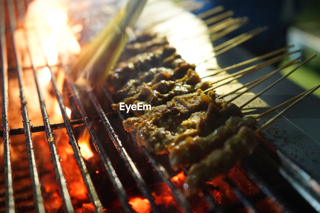 Close-up of meat satay on barbecue grill at market