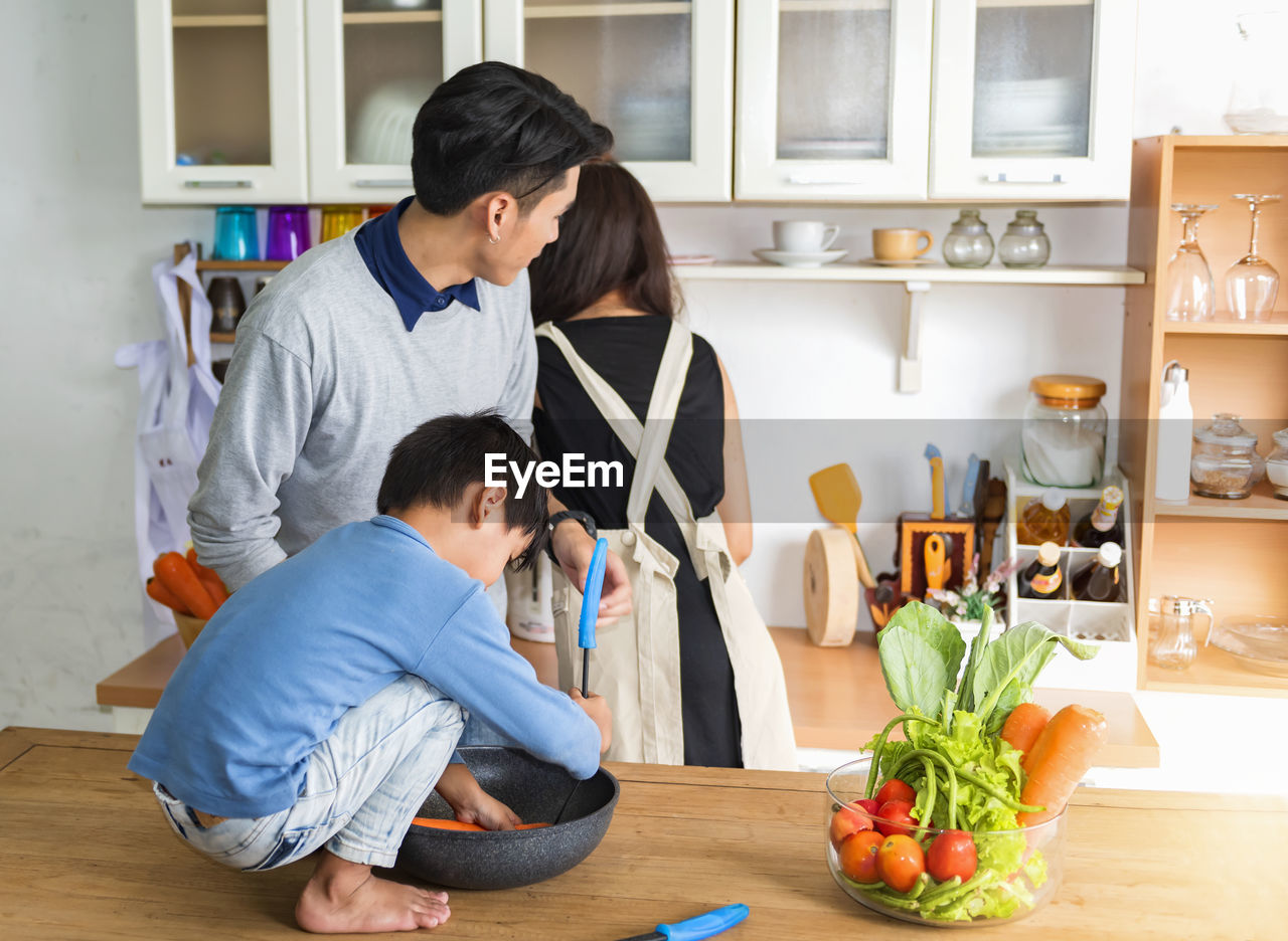 side view of boy using digital tablet while sitting on table