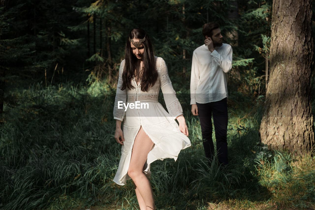 Smiling couple standing in forest