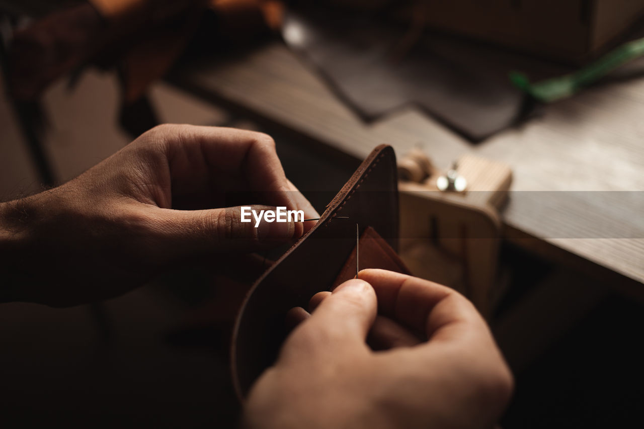 Tanner sews with threads makes leather purse. diy instruction. eco production, entrepreneur.