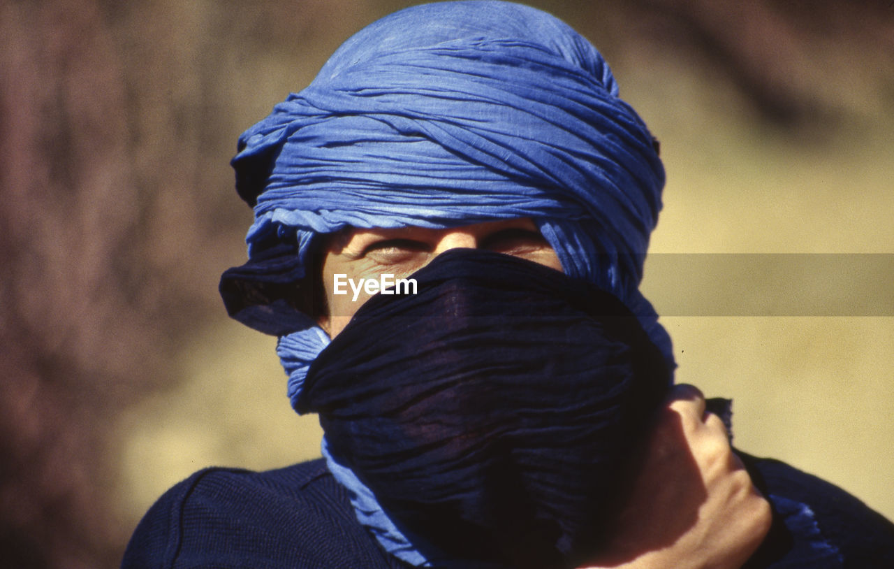 Close-up portrait of man covering face outdoors