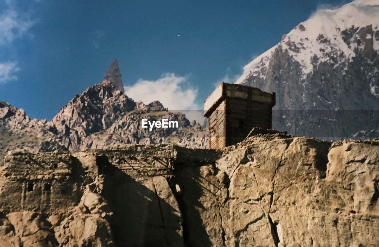 Low angle view of rocks and mountains with 
 a fort against sky