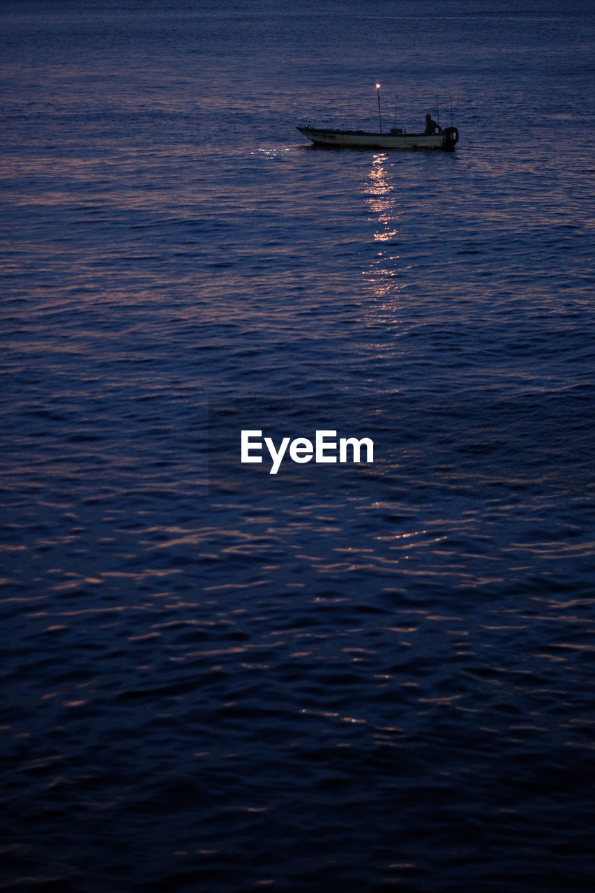 BOAT SAILING IN SEA AGAINST SKY