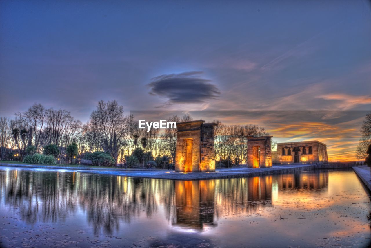 REFLECTION OF BUILDINGS IN LAKE AT DUSK