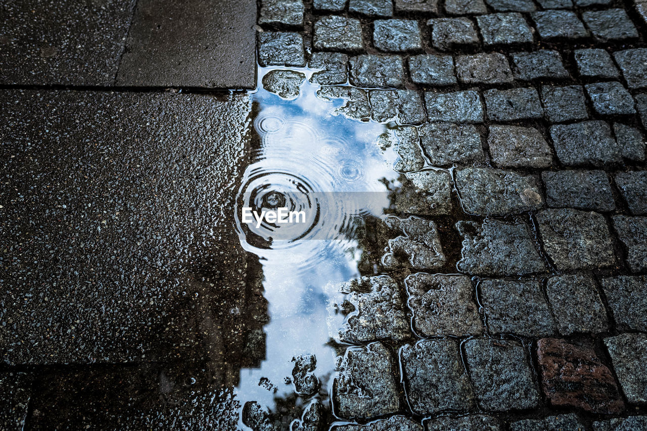 High angle view of rippled puddle on footpath