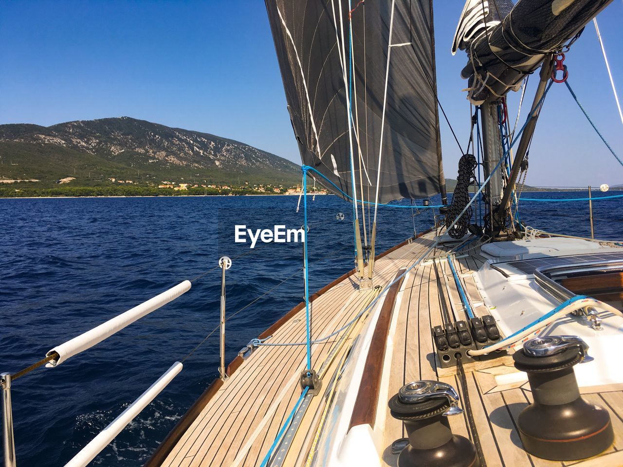 SAILBOATS SAILING ON SEA BY MOUNTAINS AGAINST SKY