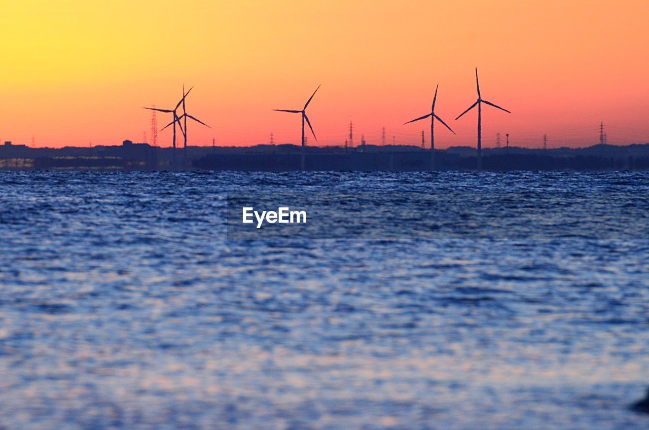Calm sea with wind turbines in distance