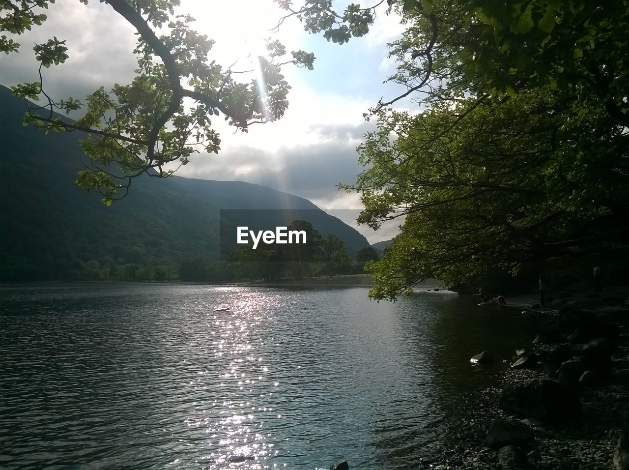 SCENIC VIEW OF LAKE BY TREE MOUNTAIN AGAINST SKY