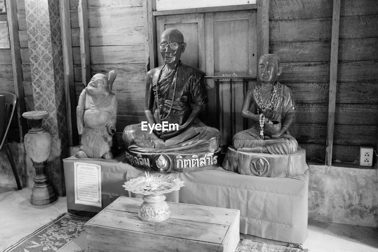 STATUE OF BUDDHA SITTING IN SHELF
