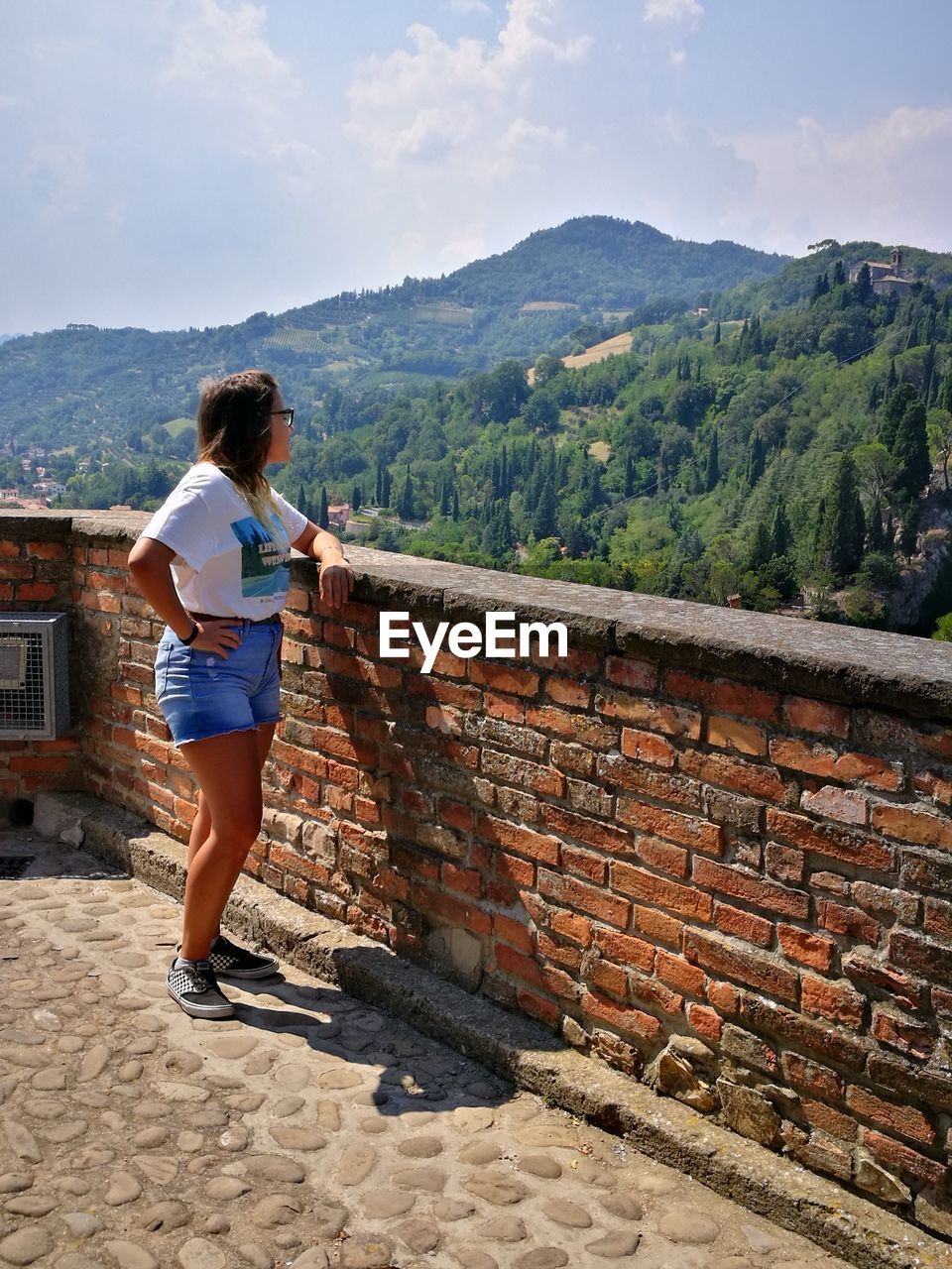 FULL LENGTH REAR VIEW OF WOMAN STANDING AGAINST MOUNTAIN