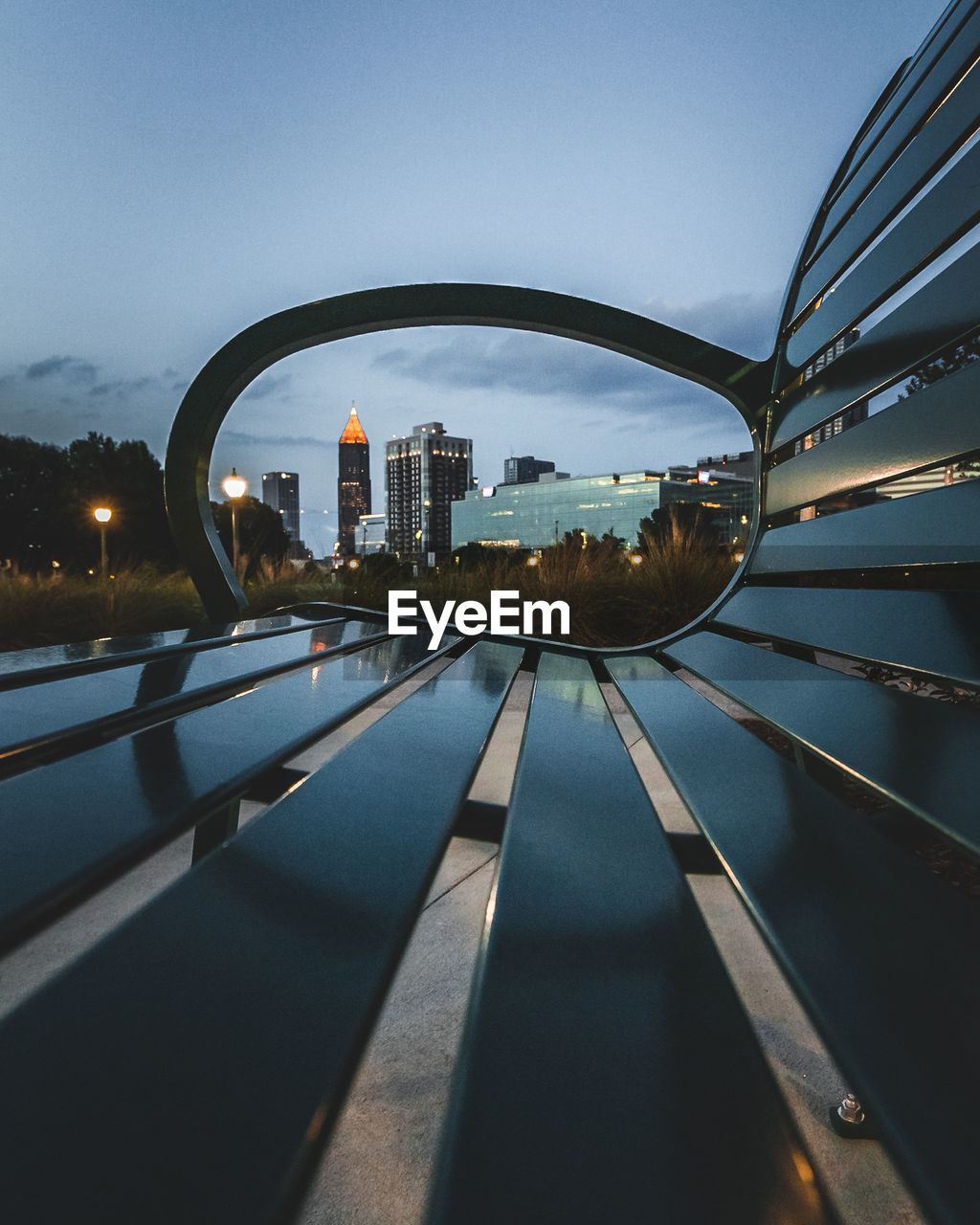 Part of atlanta skyline framed thru park bench.